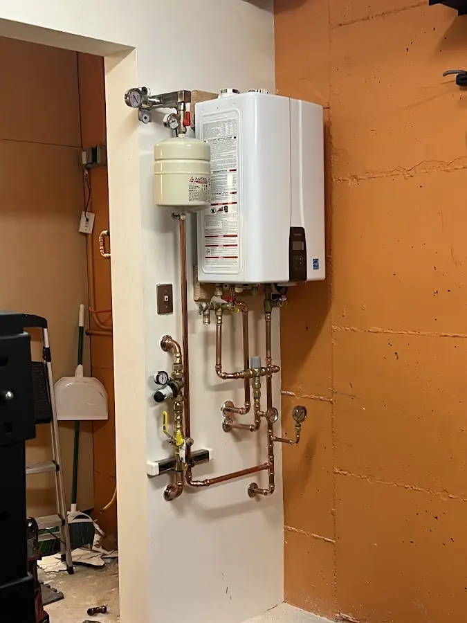 Plumbing technician inspecting water heater connections in Cheyenne